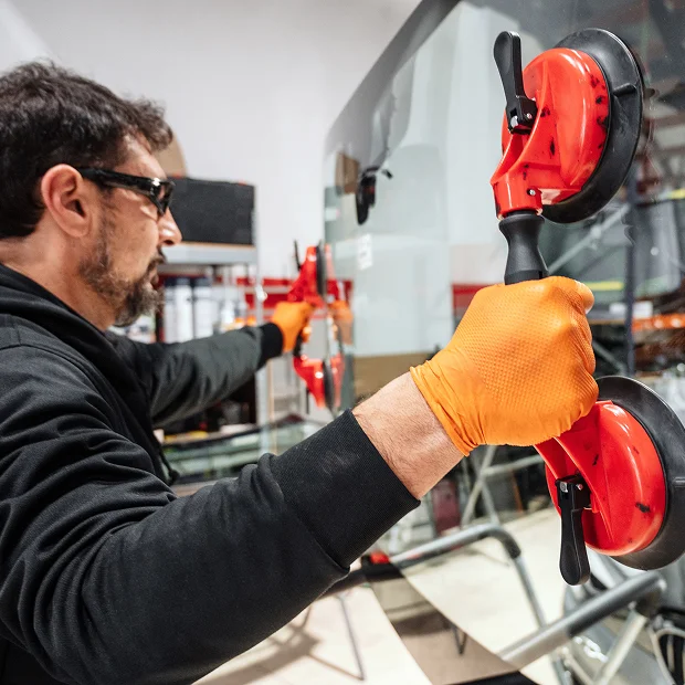 Homme ganté tenant des ventouses pour manipuler une vitre de voiture Les Essarts-le-Roi dans les Yvelines 78